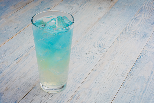 Slurp Juice cocktail in a tall glass with layered blue and yellow colors over ice