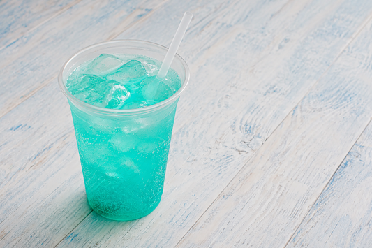 Boozy Baha Blast cocktail in a clear cup with ice and a straw