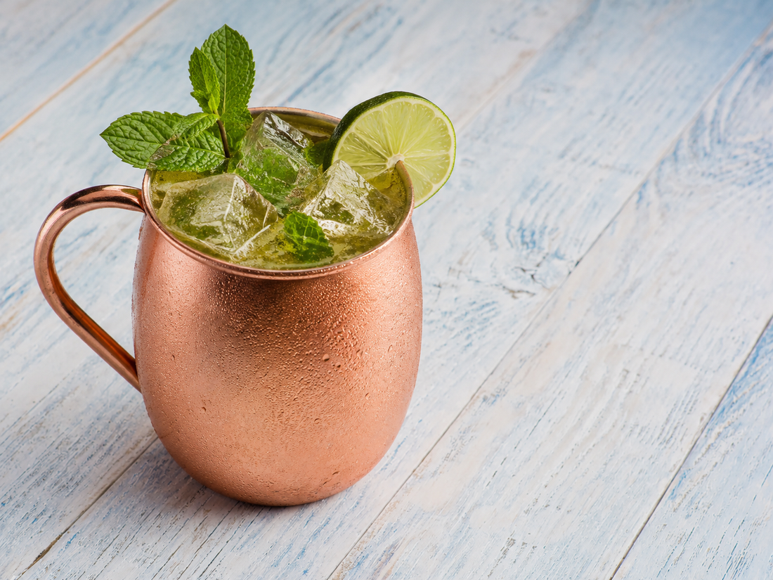 Green Tea Mule cocktail in a copper mug with ice, mint, and a lime wheel