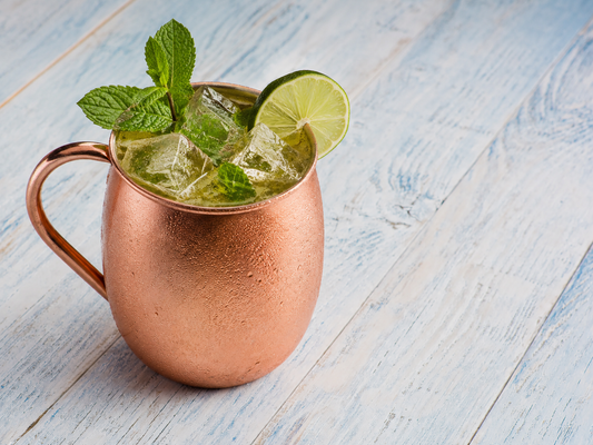 Green Tea Mule cocktail in a copper mug with ice, mint, and a lime wheel